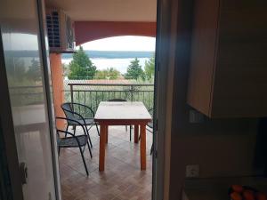 una mesa y sillas en un balcón con vistas en Apartment Dora, en Gornji Karin