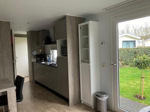 a kitchen with a counter and a window and a table at Meerchalets in Biggekerke