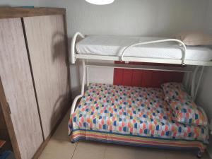アグアス・デ・リンドイアにあるRecanto do Sossegoの二段ベッド1組とベッドシーツが備わる小さな客室です。