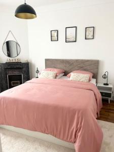 - une chambre avec un lit rose et un miroir dans l'établissement Maison chaleureuse proche Paris, à Châtillon