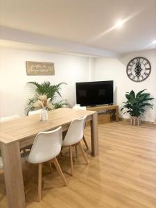 a dining room with a table and chairs and a tv at Maison chaleureuse proche Paris in Châtillon