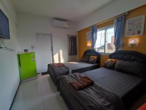 a room with two beds and a green refrigerator at Psm at Donmueng in Ban Don Muang (1)