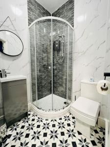 uma casa de banho com um chuveiro e um WC. em 4 Beds 3 Bath (2-ensuites) Free Parking 75Mbps em Stoke on Trent