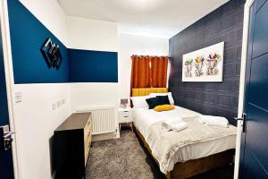 niewielka sypialnia z łóżkiem i niebieskimi ścianami w obiekcie 4 Beds 3 Bath (2-ensuites) Free Parking 75Mbps w mieście Stoke-on-Trent