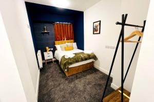 sypialnia z łóżkiem i niebieską ścianą w obiekcie 4 Beds 3 Bath (2-ensuites) Free Parking 75Mbps w mieście Stoke-on-Trent