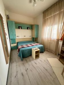 um quarto com uma cama com um edredão verde em Bilocale al mare em Rimini