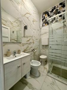 uma casa de banho com um lavatório, um WC e um chuveiro em Bilocale al mare em Rimini