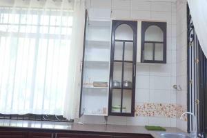 a kitchen with a sink and a glass cabinet at Shimbo Homes in Kutani