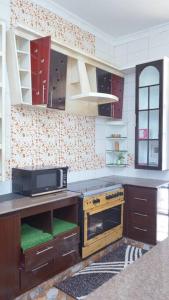 a kitchen with a stove and a microwave at Shimbo Homes in Kutani