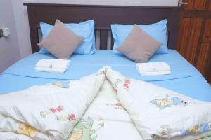 a bed with blue sheets and pillows on it at Shimbo Homes in Kutani
