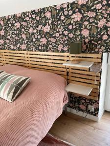 a bedroom with a bed with a flowery wall at La Martinière in Saint-Martin-sur-Oust