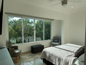 a bedroom with a bed and a large window at Home in Puerto Morelos 5BD 7BR Roof Toop Pool in Puerto Morelos