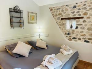 a bedroom with a bed with towels on it at Les Gîtes et la Chambre de Labahou SPA in Anduze