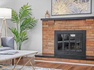 a living room with a brick fireplace with a fire place at Stylish and Accessible Six Bedroom Home in Wexford/Pittsburg With Kids Amenities in Wexford