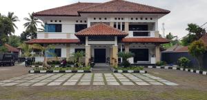 a large house with a courtyard in front of it at Hotel pondok putri in Batukaras