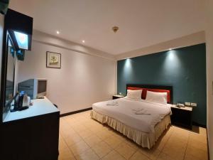 una camera d'albergo con letto e TV di Desa Phuket a Phuket
