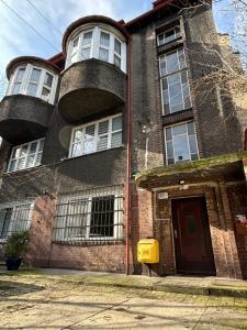 an old brick building with a balcony on top of it at KK Apartament Piekarska Oficyna in Bytom