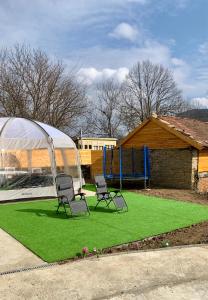 zwei Stühle auf einer Wiese mit Spielplatz in der Unterkunft Lipite Guest House 