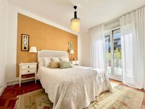 1 dormitorio con cama blanca y ventana en Luxury House Center Baiona en Baiona