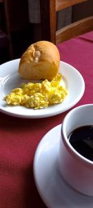 a plate with scrambled eggs and a bagel on a table at HOTEL JP in Delfinópolis