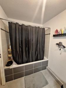 a bathroom with a shower with a black shower curtain at Appartement T2 à Montpellier in Montpellier
