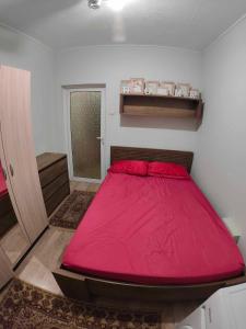 Cette petite chambre comprend un grand lit rouge. dans l'établissement Zoev, à Plovdiv