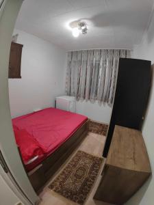 a small bedroom with a red bed and a window at Zoev in Plovdiv