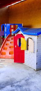 a toy house and a play house with a slide at HOTEL JP in Delfinópolis