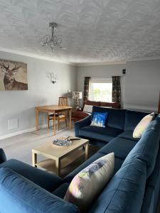 sala de estar con sofá azul y mesa en Lochans Lodge, en Stranraer