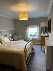 una camera d'albergo con letto e finestra di Lochans Lodge a Stranraer