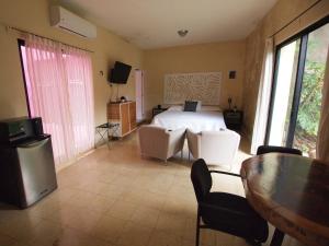 - une chambre avec un lit, une table et des chaises dans l'établissement Villas Candita, à Mérida