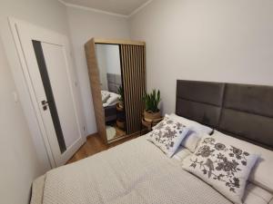 a bedroom with a bed and a large mirror at Ustronny Zakątek in Ustroń