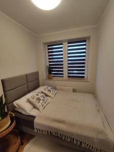 a bedroom with a bed and a window at Ustronny Zakątek in Ustroń