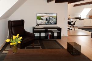 a living room with a chair and a television at Lejlighed med et eller to separate soveværelser in Ribe