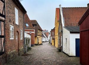 an empty alley in a town with brick buildings at Lejlighed med et eller to separate soveværelser in Ribe