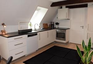 a kitchen with white cabinets and a sink and a window at Lejlighed med et eller to separate soveværelser in Ribe