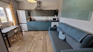 uma sala de estar com um sofá azul e uma cozinha em Estudio Mirador Dorado em Málaga