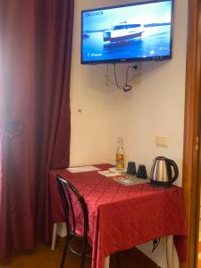 a room with a table with a television on the wall at Residenza in Rome