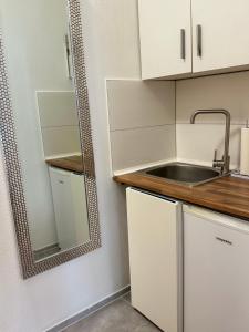 a small kitchen with a sink and a mirror at Einfaches Appartement "Daniel" in Halle in Kröllwitz