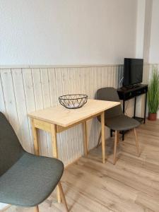 a wooden table with two chairs and a desk at Einfaches Appartement "Daniel" in Halle in Kröllwitz