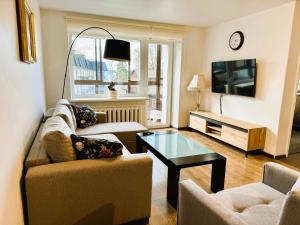 a living room with two couches and a tv at Apartment in the City center in Druskininkai