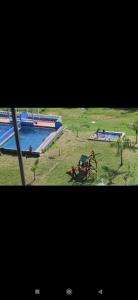duas fotos de uma piscina em um campo em Finca Descanso Fronterita em San Jerónimo