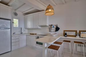 eine Küche mit weißen Schränken und einer Leuchte in der Unterkunft Villa Sea Angels in Kalafatis