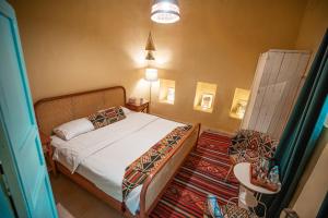 sypialnia z łóżkiem, stołem i oknem w obiekcie Jordan Heritage Madhafa w mieście As-Salt
