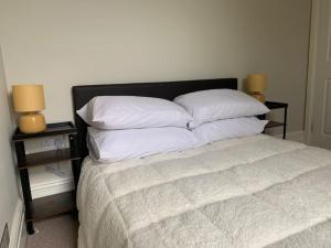 a bedroom with a bed with pillows and two night stands at Central 2 bed flat. Free parking (Off-street) in Bristol