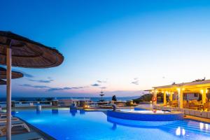 a pool at a resort with a view of the ocean at Kavuras Village in Agios Prokopios