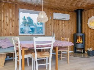 ein Esszimmer mit einem Tisch, Stühlen und einem Kamin in der Unterkunft Holiday Home Hesselhus in Abildskov