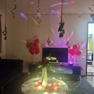 sala de estar con mesa con globos y TV en Queen Home en Luzern