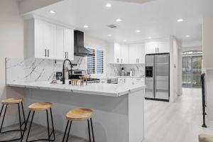 a white kitchen with a counter and stools in it at Universal studios getaway in Los Angeles