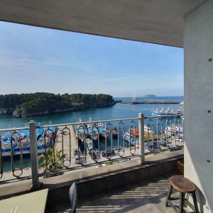 un balcón con vistas a un cuerpo de agua en Seom Guesthouse, en Seogwipo